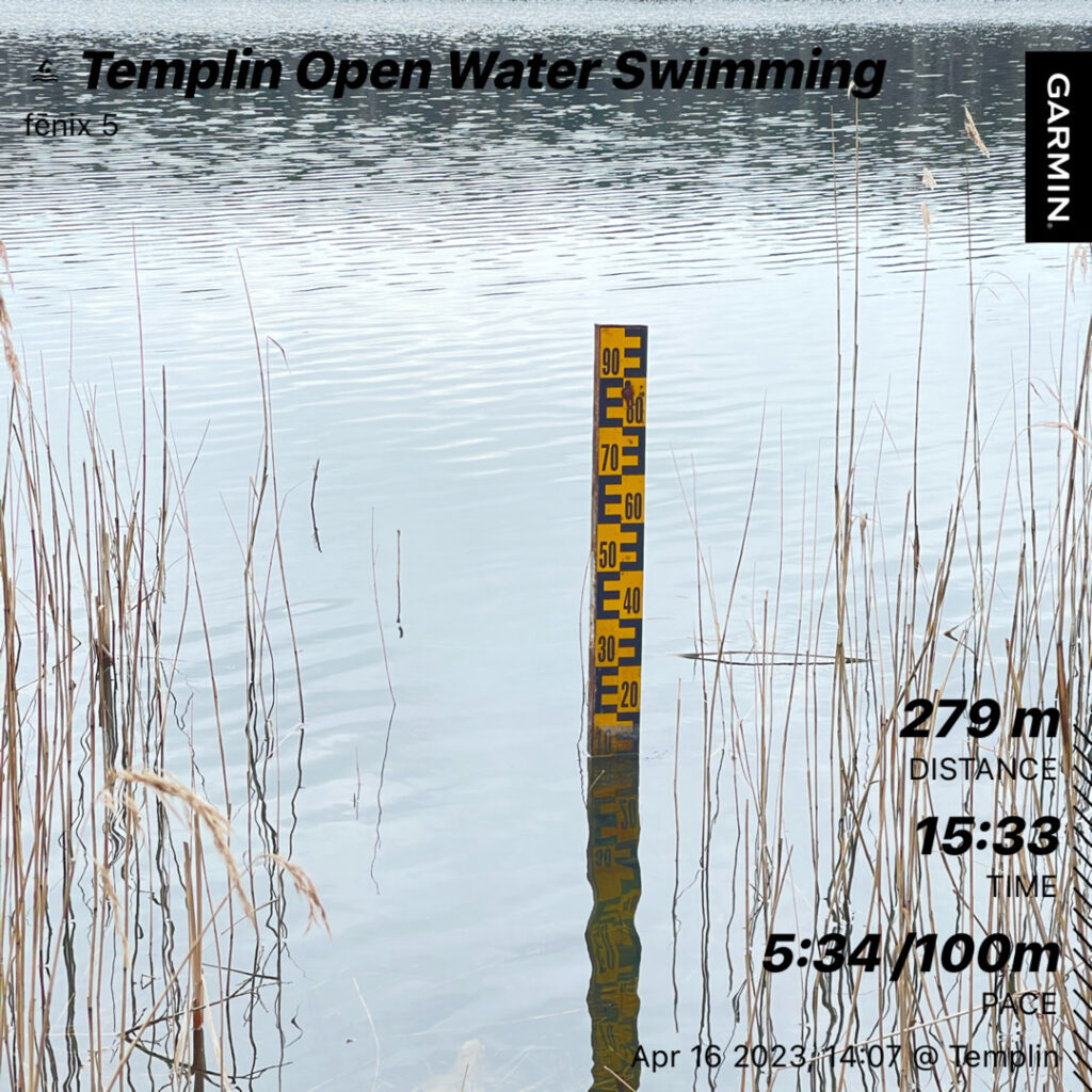 A lake with a water level gauge in it. some reed can be seen left and right. The images contains some text over lay: Templin OpenWater swimming, Distance 279m, Time 15:33, Pace 5:34/100m
