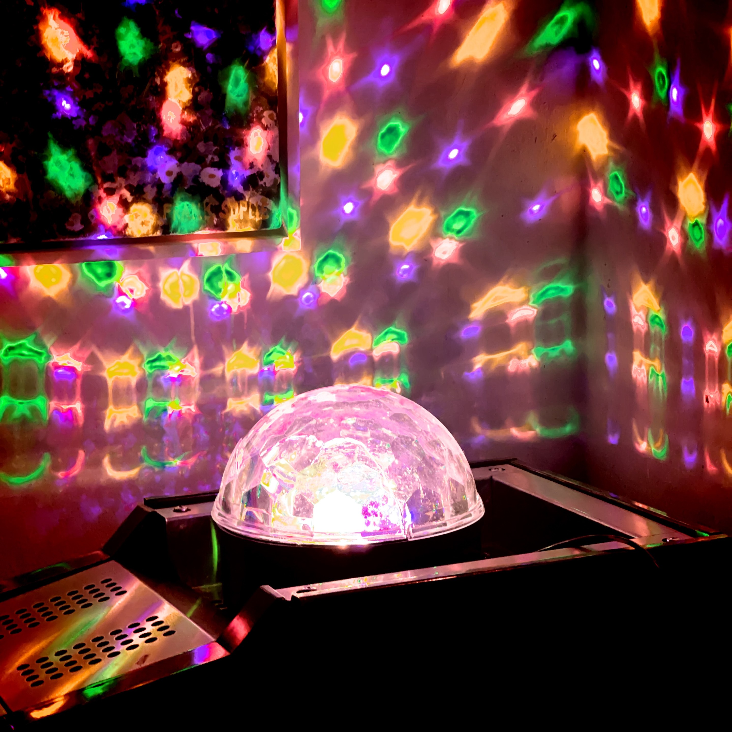 Ein Discolichtprojektor wirft bunte, gemusterte Lichter an Wände und Decke.