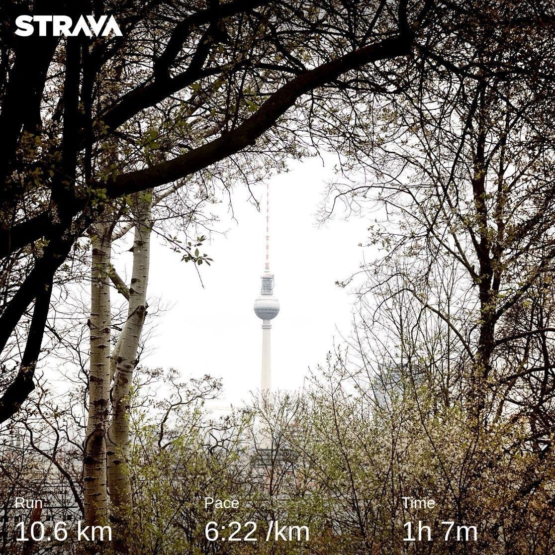 Ein Screenshot einer Strava-Aktivität zeigt eine Laufstrecke von 10,6 km, eine Pace von 6:22/km und eine Zeit von 1 Stunde 7 Minuten vor einem Hintergrundbild mit einem zwischen Bäumen sichtbaren Fernsehturm.